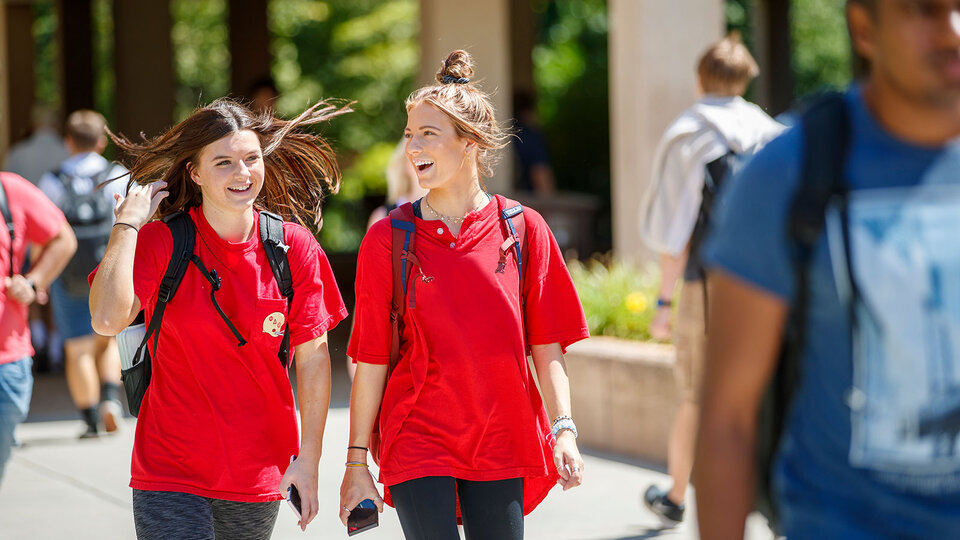 students in red walking on campus to class